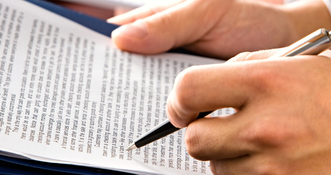 met een pen in de hand een contract nalopen