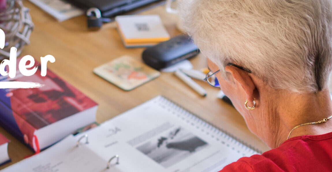 Vrouw zit aan een tafel te lezen