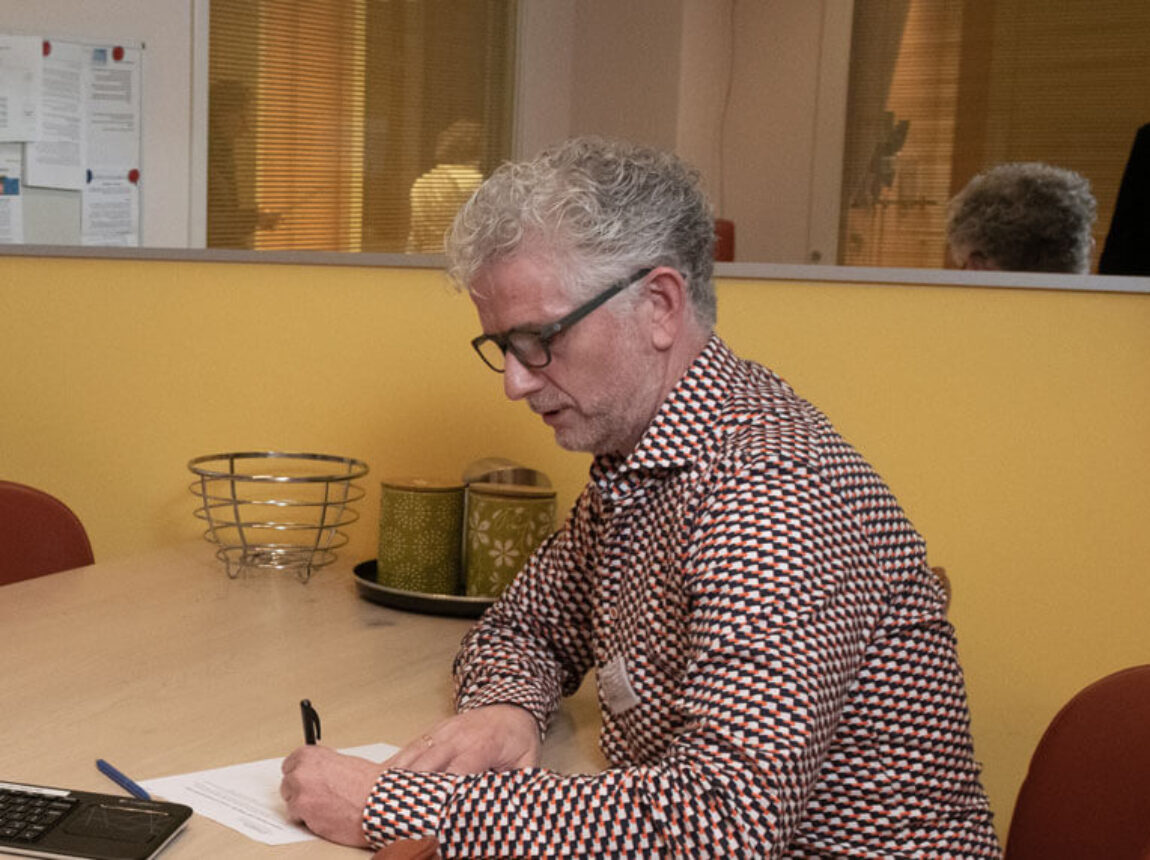 Mensen zitten bij elkaar aan tafel op de huisartsenspoedpost