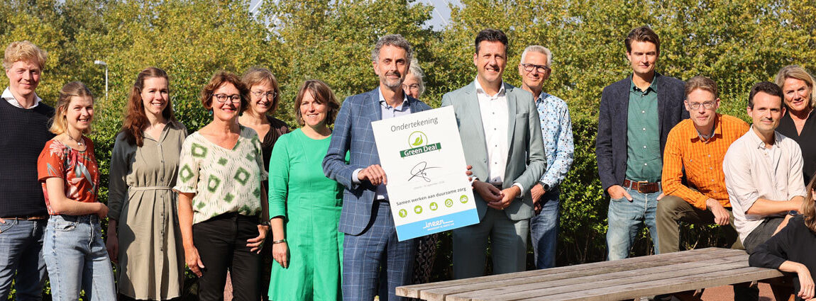 InEen ondertekent Green Deal Duurzame Zorg. Paulus Lips temidden van leden met de ondertekende Green Deal in zijn hand.