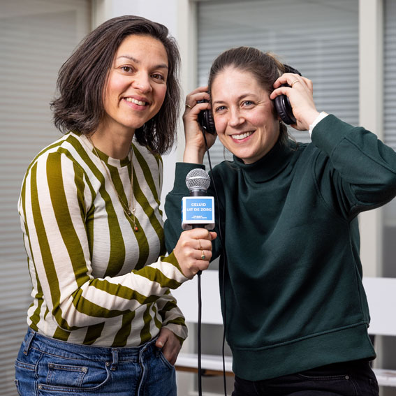 Twee vrouwen, een met een microfoon en een met een koptelefoon