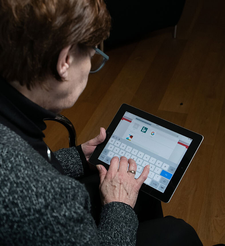 Oudere vrouw kijkt op een tablet