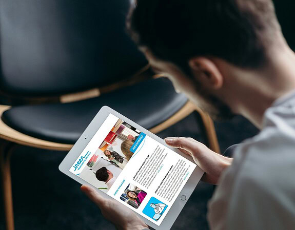 Jongeman leest de InEen nieuwsbrief op een tablet.