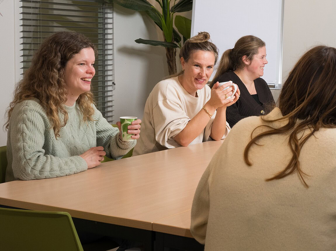 Groepje collega's aan de koffietafel met elkaar in overleg